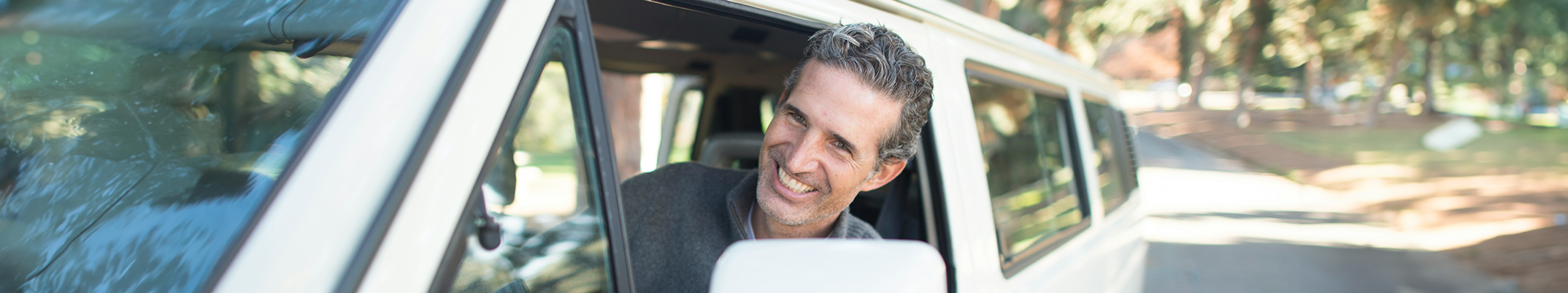 photo of man driving van with his head out the driver's side window